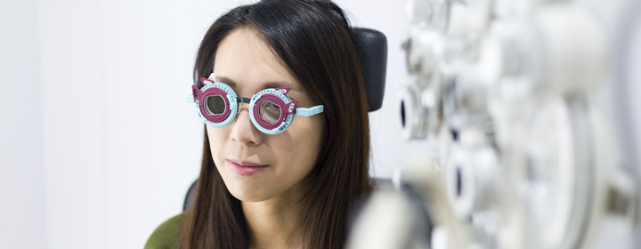 Chica joven en el gabinete graduándose con gafas de prueba
